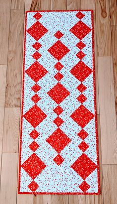 a red and white quilt is laying on the floor