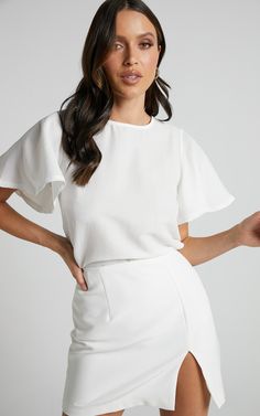 The Enzo Top is the perfect addition to your wardrobe. With its flutter sleeves and scoop neck, it adds a touch of femininity to any outfit. Made from breathable cotton, this fashion top will keep you comfortable all day long. Whether you're looking for a casual or workwear option, this white short sleeve top has got you covered. Its standard fit makes it easy to pair with your favorite jeans or dress pants, while its winter-appropriate color ensures that you stay on-trend throughout the season. White Short Sleeve Top For Workwear In Summer, Elegant White Blouse With Flutter Sleeves, White Feminine Tops With Butterfly Sleeves, White Feminine Blouse With Butterfly Sleeves, Feminine White Butterfly Sleeve Blouse, Chic White Short Sleeve Top For Summer, Elegant White Blouse With Butterfly Sleeves, Elegant White Butterfly Sleeve Blouse, White Short Sleeve Tops