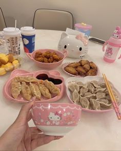 a table with hello kitty plates and bowls on it