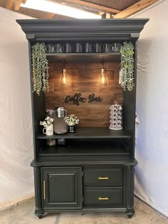 a black cabinet with some plants on top