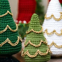 three crocheted christmas trees sitting next to each other on top of a table