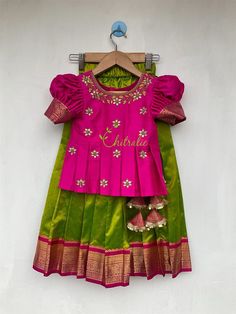 Lime green Kanchipuram silk pattupavadai with rani pink silk peplum top. Fabric and Work: Top: . Fabric used is silk and is embellished with maggam work. The dress is lined with soft cotton fabric. The top has opening at back side. Skirt: Kanchipuram lime green silk fabric with dark pink jacquard boarder and also lined with a cotton fabric to give comfort for your little one. The skirt has an elastic waist band at waist line, If you need petticoat skirt or tie we will customize it for you. Your Celebration Green Dress With Pallu, Green Dresses For Navratri Celebration, Green Art Silk Dress For Celebration, Green Dress For Navratri Celebration, Green Silk Lehenga For Celebration, Green Celebration Dress For Navratri, Green Saree Dress For Celebration, Green Choli With Dori Work For Celebration, Green Anarkali Choli For Celebration