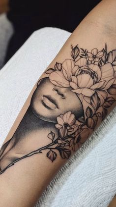 a woman's face with flowers on her arm