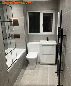 a white toilet sitting in a bathroom next to a bathtub and sink under a window