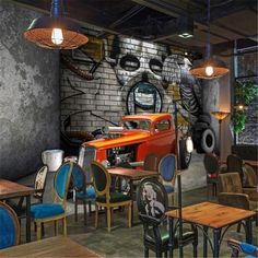 the interior of a restaurant with tables, chairs and an old car painted on the wall