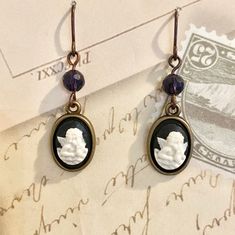 Angel Cameo Earrings, Small Black White Cameo Earrings, Black Crystal Cameo Earrings, Cameo Drop Earrings, Goth Cameo Dangle Earrings  Add a touch of vintage - inspired beauty to your look with these classic black and white cameo earrings, vintage in style. Dress to impress with these dainty cameo vintage style cameo earrings, handmade for you using romantic acrylic cameos with little cherub angels, the bronze cameo earring setting and bead caps in antique bronze add that perfect vintage touch o Cameo Drop Earrings Jewelry Gift, Cameo Drop Earrings As Gift, Gift Cameo Drop Earrings Jewelry, Cameo Drop Earrings For Gifts, Cameo Round Earrings As Gift, Victorian Style Single Earring For Gift, Cameo Earring, Earrings Goth, Victorian Cameo