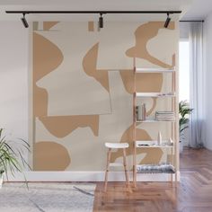 an abstract painting on the wall in a room with wooden flooring and white walls