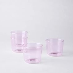 three pink glass cups sitting next to each other