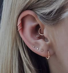 a close up of a person wearing an ear with two piercings on their ears