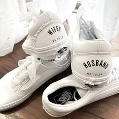 two white shoes with black and white logos on them