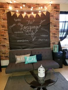 a couch sitting in front of a chalkboard on the wall next to a window