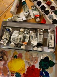 an artist's palette with paint and watercolors