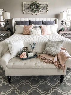 a white bed with pillows and blankets on it