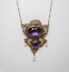 "Item #: ANK-2002 Beautiful Antique Edwardian Filigree Amethyst and FW Seed Pearl Necklace This totally stunning necklace is intricate in design with gorgeous large amethysts securely set in bezels. The chain is a vintage new 14K Yellow Gold fine bar chain. Style: Edwardian Metal: Chain is 14K yellow gold The pendant is Sterling Silver that has been gold plated (Vermeil) - acid tested Center Stone: large oval genuine Amethyst Center Stone Dimensions: 22.34mm x 16.12mm x 10.69mm deep oval in beze Luxury Victorian Amethyst Jewelry, Ornate Jeweled Necklaces For Formal Occasions, Gold Amethyst Necklace For Wedding, Wedding Gold Necklace With Amethyst, Exquisite Oval Filigree Necklace, Victorian Jeweled Necklaces For Formal Occasions, Jeweled Pendant Jewelry For Evening, Exquisite Large Pendant Jewelry For Wedding, Exquisite Wedding Jewelry With Large Pendant