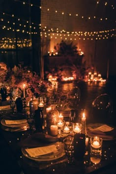 a long table with candles and plates on it