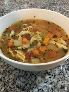 a white bowl filled with soup sitting on top of a counter