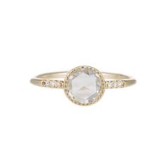 the gold ring with an oval cut stone and diamonds on it, set against a white background