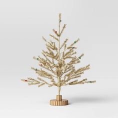 a small white christmas tree in a wooden stand