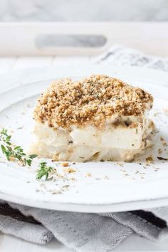 a white plate topped with a dessert covered in crumbs