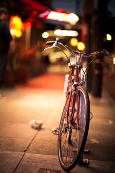 a bike parked on the side of a street next to a sidewalk with words written in spanish