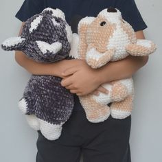 a little boy holding two stuffed animals in his hands