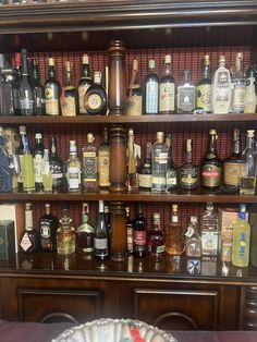 a shelf filled with lots of liquor bottles