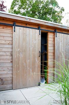 an outside view of a wooden shed with the door open