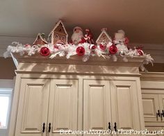 christmas decorations on top of cabinets with santa clause and other ornaments in the corner above them