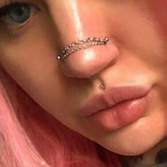 a woman with pink hair and piercings on her nose