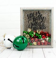 two christmas ornaments sitting next to each other in front of a frame with writing on it