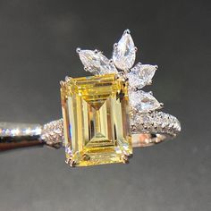 a yellow diamond ring sitting on top of a table