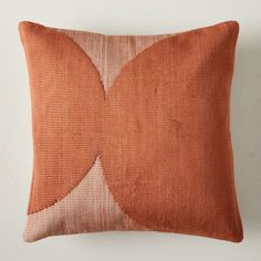 an orange and white pillow sitting on top of a wall