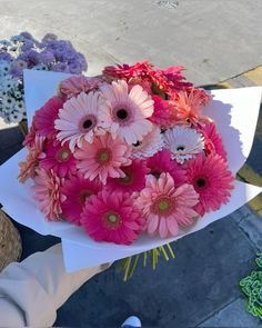 a bouquet of pink and white flowers in someone's hand