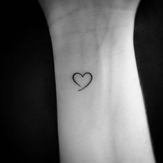 a small heart tattoo on the wrist