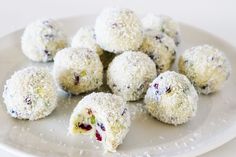 a white plate topped with cut in half desserts covered in powdered sugar and cranberries