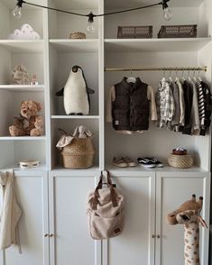 an organized closet with stuffed animals and clothes hanging on the wall, along with other baby items