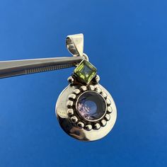 * Designer 925 Sterling Silver Smoky Quartz Peridot Statement Drop Pendant * Length: 1-1/4" including the bale * Width: 1/8" to 3/4" * Smoky Quartz total carat weight: approximately 2.15 tcw * Peridot total carat weight: approximately 1.25 tcw * Weight: 5.9 tgw * Marked: Makers Mark * 925 * Chain is not included, but can be purchased for an additional price. * Condition: Great, as pictured. * S3498    Exported By ExportYourStore :) Round Multi-stone Gemstones For May Birthstone, Sterling Silver Multi-stone Round Pendant, Sterling Silver Multi-stone Jewelry, Sterling Silver Multi-stone Round Jewelry, Sterling Silver Multi-stone Round Pendant Jewelry, Round Multi-stone Sterling Silver Gemstones, Sterling Silver Multi-stone Jewelry With Round Stones, Round Multi-stone Gemstones In Sterling Silver, Sterling Silver Round Pendant Gemstone For Anniversary