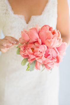 a bride holding a bouquet of pink flowers