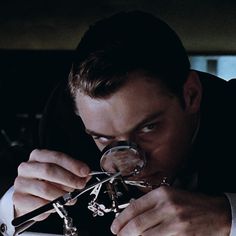 a man looking through a magnifying glass in front of his eyeglasses