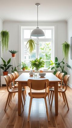 a dining room table surrounded by potted plants