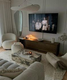 a living room filled with furniture and a flat screen tv mounted to the side of a wall