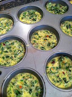 muffin tins filled with eggs and vegetables on top of a stovetop oven