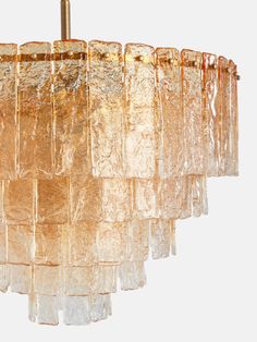 a chandelier made out of glass blocks hanging from a metal rod with a light fixture in the middle