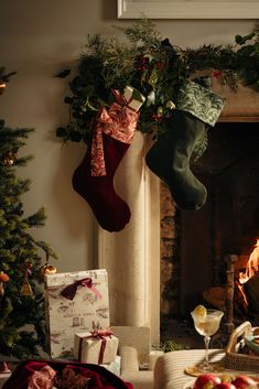 christmas stockings hanging from the fireplace with presents under them