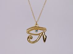 The Eye of Horus necklace is a mystifying piece of jewellery. The necklace features a pendant that is crafted in the shape of the Eye of Horus, an ancient Egyptian symbol of protection, power, and good health. The pendant is made of 22k gold vermeil and has a high polish finish, giving it a luxurious and radiant appearance. The Eye of Horus is intricately designed with fine curving details to create a subtle dramatic effect. At the center of the Eye of Horus pupil is a brilliant 2.3mm sapphire, which captivatingly brings the piece alive. It is carefully selected for its quality and is set in a secure and elegant bezel setting. The pendant measures approximately 2cm x 2cm and hangs on a delicate chain that complements the design and adds a touch of divine femininity to the piece. The chain Symbolic Yellow Gold Ceremonial Necklace, Ceremonial Gold Plated Amulet Necklace, Symbolic Ceremonial Necklace With Locket, Symbolic Ceremonial Locket Necklace, Symbolic Locket Necklace For Ceremonial Use, Ceremonial Gold Plated Pendant Necklace, Amulet Style Ankh Necklace In Brass, Gold Ceremonial Pendant Necklace, Symbolic Gold Plated Locket Necklace