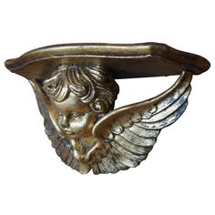 an antique brass gargoyle head with wings hanging from it's back end