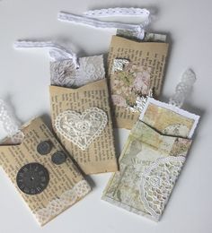 four pieces of altered paper with buttons and laces on them are sitting next to each other