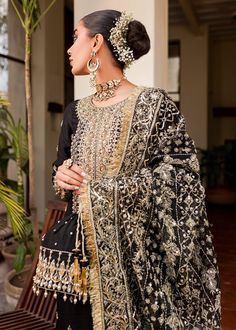 Black Gold Shirt Palazzo for Pakistani Wedding Dresses is fully embellished in the work of dabka, kora, tilla on sharara, and short shirt with net embroidered dupatta. You are all set to make a lasting effect in this dress. Kameez Shirt: A traditional silk shirt features a heavy long neckline with guff borders, a beautiful mix of florals, and geometry delicately rendered using sequins, naqshi among many more. Trouser: To improve the ensemble, it features a silk palazzo with an outstanding extens Kanwal Malik, Black And Gold Shirt, Pakistani Clothes Online, Pakistani Designer Clothes, Luxury Pret, Potli Bag, Shirt Korean, Pakistani Clothes, Gold Shirt