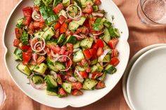 a white bowl filled with cucumbers and onions on top of a wooden table