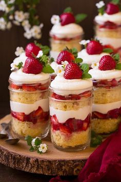 several small jars filled with desserts on top of a wooden table next to each other